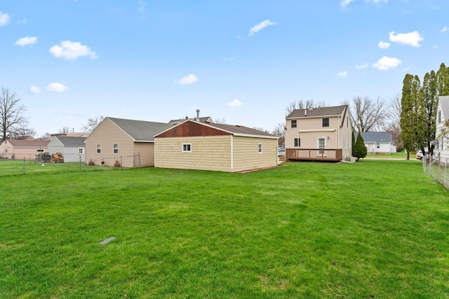 rear view of property with a lawn, a wooden deck, and a fenced backyard
