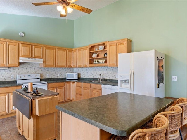 1587 Stallion Rd SW, Pillager, MN 56473 - kitchen featuring light brown cabinetry, dark countertops, white appliances, under cabinet range hood, and a kitchen island