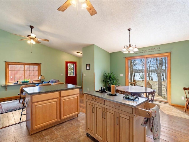 1587 Stallion Rd SW, Pillager, MN 56473 - kitchen featuring baseboards, vaulted ceiling, a center island, and ceiling fan with notable chandelier