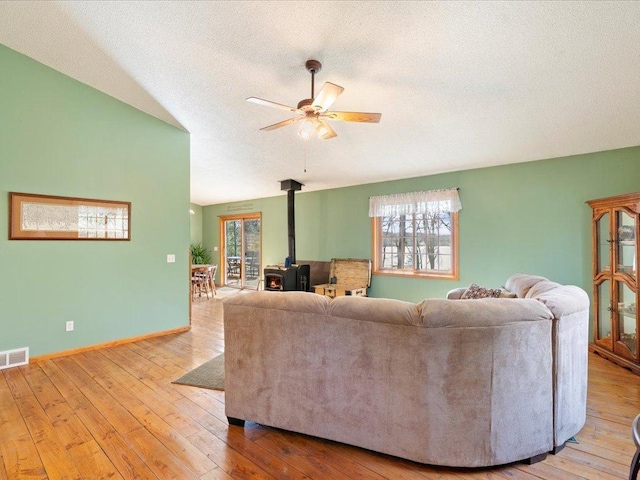 1587 Stallion Rd SW, Pillager, MN 56473 - living room featuring a wealth of natural light, a wood stove, visible vents, and vaulted ceiling
