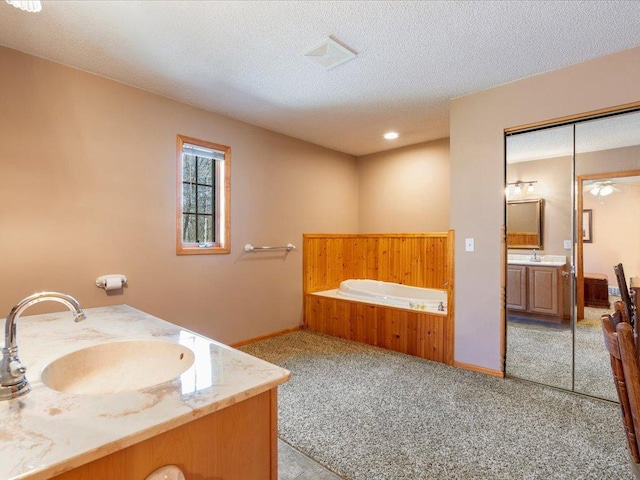 1587 Stallion Rd SW, Pillager, MN 56473 - bathroom with a textured ceiling, baseboards, vanity, and a bath