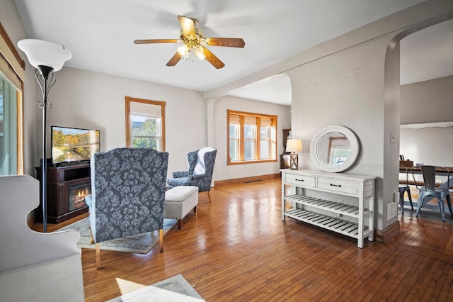 13150 345th Ave, Waseca, MN 56093 - living area with arched walkways, ceiling fan, and wood-type flooring