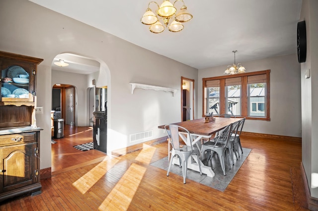 13150 345th Ave, Waseca, MN 56093 - dining area featuring arched walkways, an inviting chandelier, light wood finished floors, baseboards, and visible vents