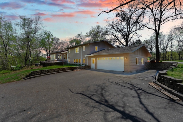 view of front facade featuring asphalt driveway and an attached garage