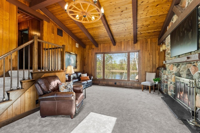 living area featuring wooden walls, stairway, wooden ceiling, a chandelier, and carpet