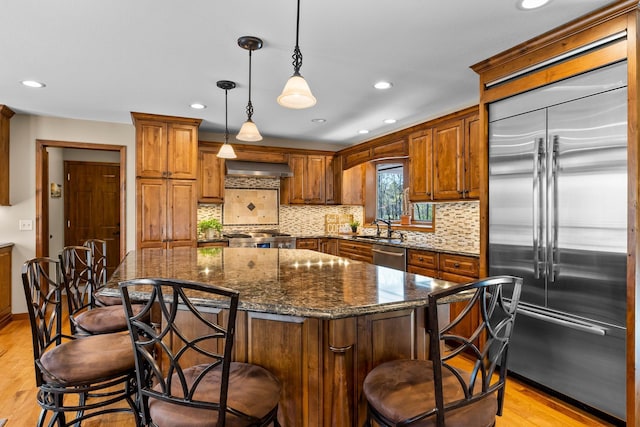 kitchen with stainless steel appliances, light wood-style flooring, a sink, recessed lighting, and tasteful backsplash