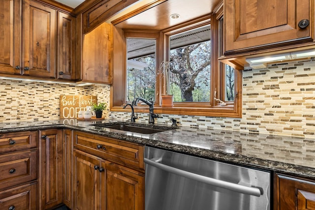 kitchen with dishwasher, decorative backsplash, a sink, and dark stone counters