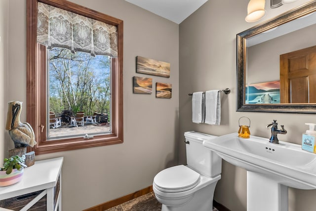 bathroom featuring baseboards, a sink, and toilet