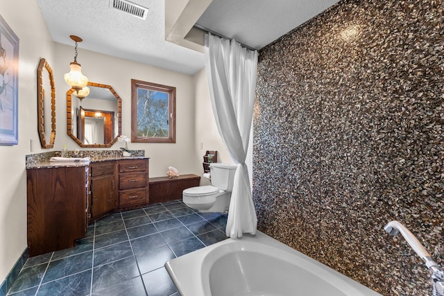 bathroom with a textured ceiling, toilet, vanity, and a tub