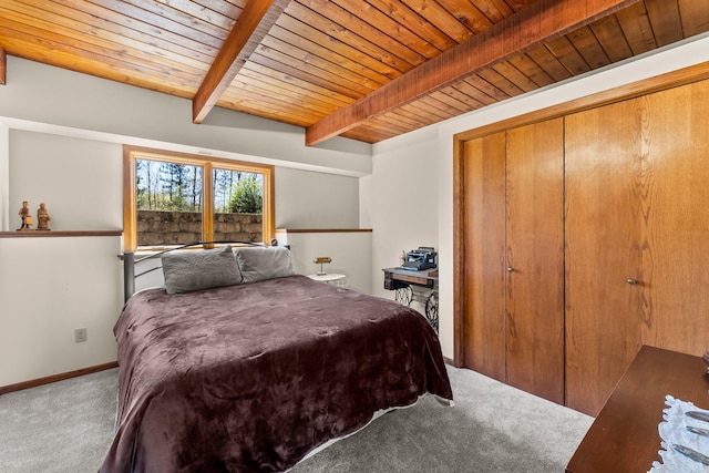 carpeted bedroom featuring beam ceiling, wooden ceiling, baseboards, and a closet