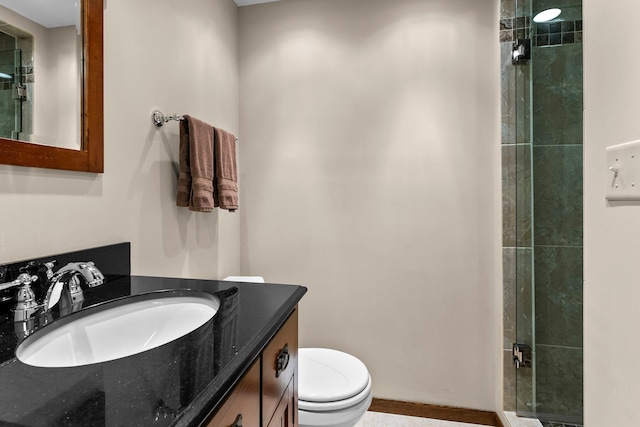 bathroom with a stall shower, vanity, and toilet