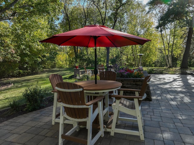 view of patio featuring outdoor dining area and view of wooded area
