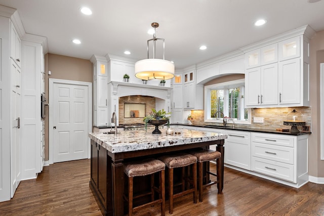 2012 Pine Ridge Dr W, Saint Paul, MN 55118 - kitchen featuring decorative backsplash, dark wood-style flooring, white cabinetry, and a kitchen bar