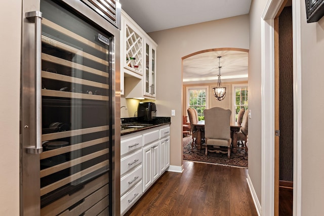 2012 Pine Ridge Dr W, Saint Paul, MN 55118 - kitchen with glass insert cabinets, arched walkways, white cabinets, wine cooler, and dark wood-type flooring