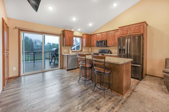 5526 Prairie Grass Dr, Brockway Twp, MN 56377 - kitchen featuring appliances with stainless steel finishes, a kitchen island, vaulted ceiling, and wood finished floors