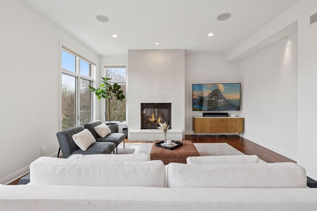 living area with recessed lighting, a high end fireplace, baseboards, and dark wood-style floors