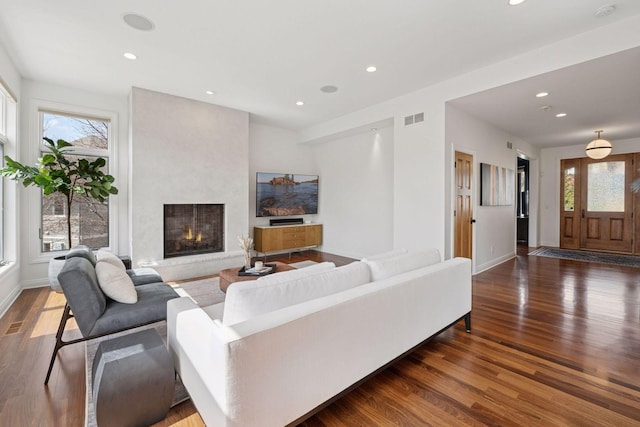 living room with visible vents, wood finished floors, a fireplace, and recessed lighting