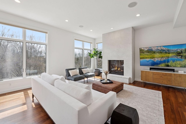 living room with recessed lighting, baseboards, dark wood-style flooring, visible vents, and a large fireplace