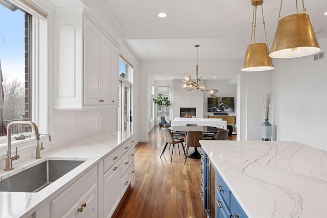 kitchen featuring white cabinetry, recessed lighting, a sink, and wood finished floors