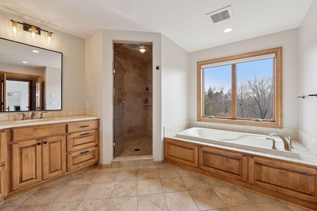 full bathroom with vanity, a bath, a shower stall, and visible vents