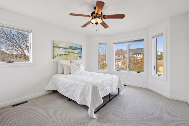 carpeted bedroom featuring visible vents, baseboards, and a ceiling fan