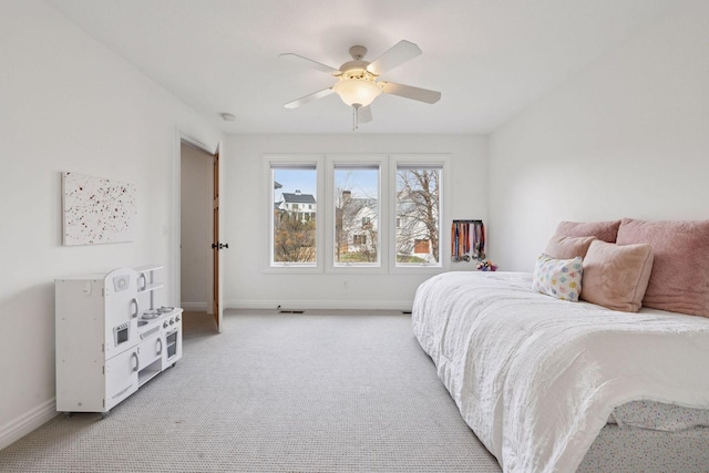 bedroom featuring baseboards, ceiling fan, and light colored carpet
