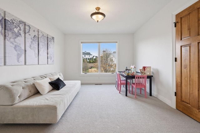 living area with light colored carpet and baseboards