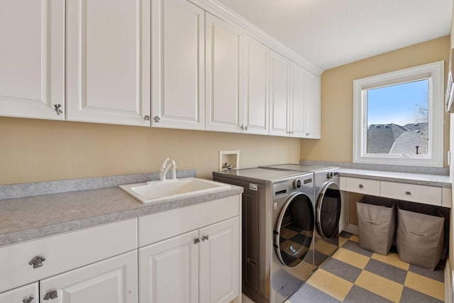 laundry area featuring independent washer and dryer, cabinet space, and a sink