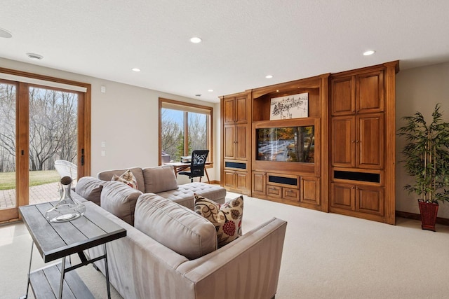 living room with a wealth of natural light, light carpet, and recessed lighting