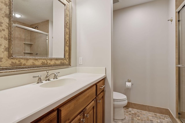 bathroom with a stall shower, toilet, baseboards, tile patterned flooring, and vanity