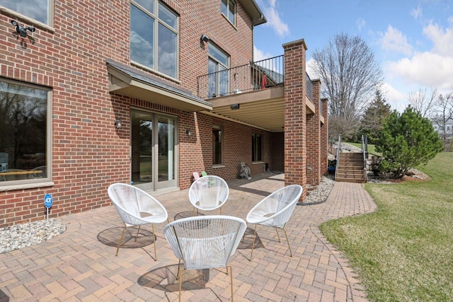 view of patio with stairway and a balcony