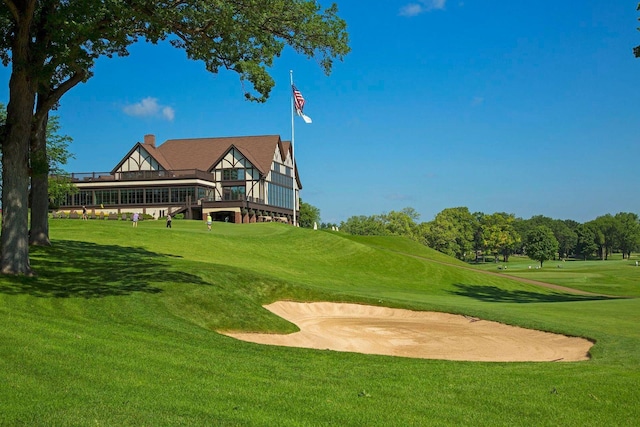 surrounding community featuring a wooden deck, golf course view, and a lawn