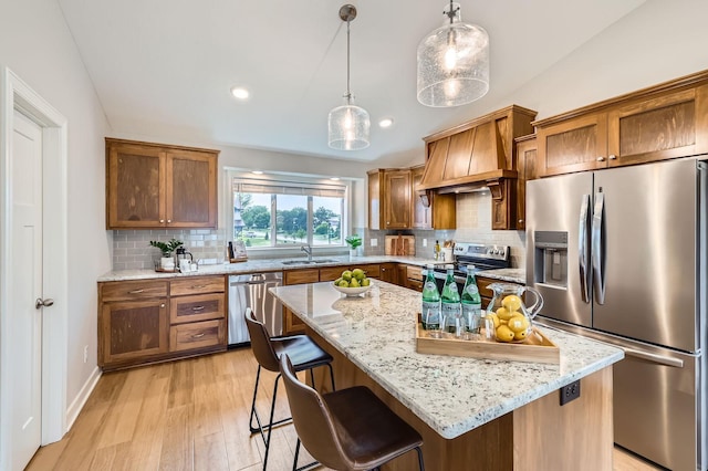 15141 Partridge St NW, Andover, MN 55304 - kitchen with stainless steel appliances, a sink, premium range hood, light stone countertops, and light wood-type flooring