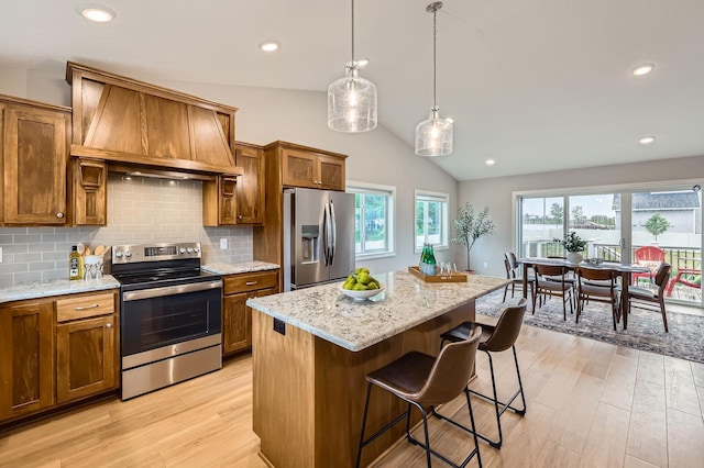 15141 Partridge St NW, Andover, MN 55304 - kitchen with appliances with stainless steel finishes, brown cabinetry, custom range hood, lofted ceiling, and light wood finished floors
