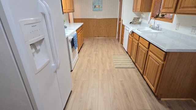 1509 2nd Ave SW, Austin, MN 55912 - kitchen with light wood-style flooring, a wainscoted wall, a sink, white appliances, and brown cabinetry