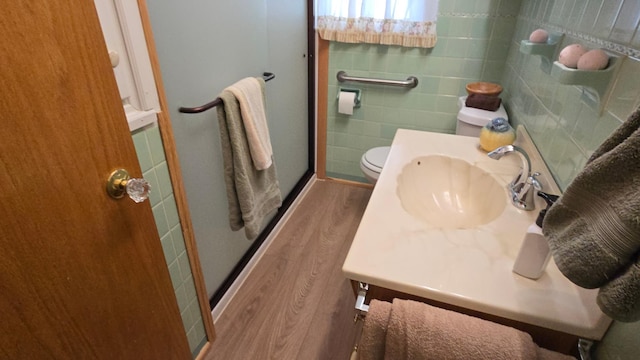 1509 2nd Ave SW, Austin, MN 55912 - bathroom with a shower stall, wood finished floors, toilet, a sink, and tile walls
