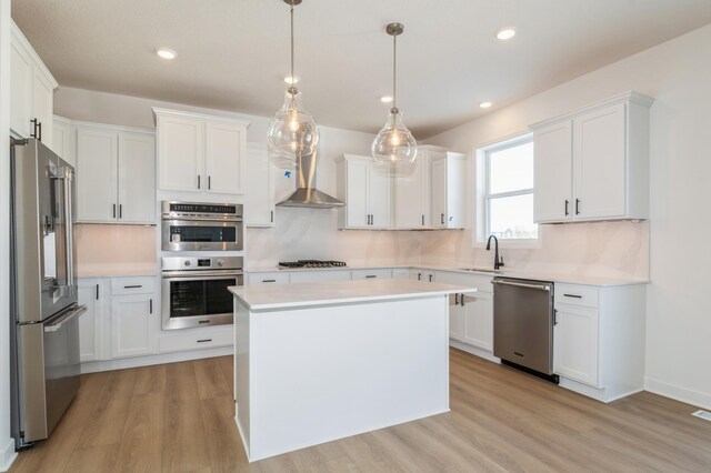 kitchen featuring white cabinets, light wood finished floors, stainless steel appliances, light countertops, and a sink