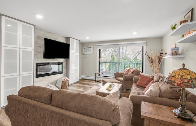 living room featuring wood finished floors, a high end fireplace, recessed lighting, baseboards, and an AC wall unit