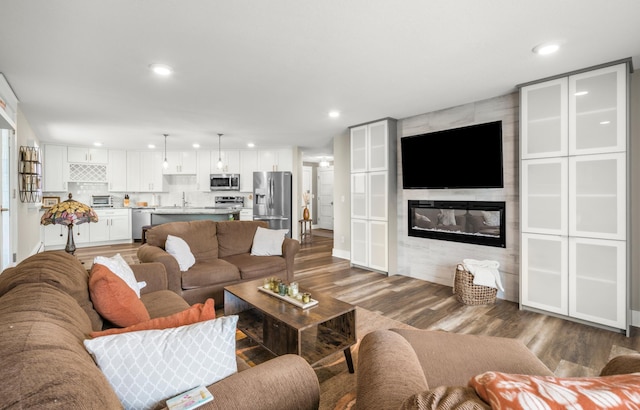 living area featuring recessed lighting, wood finished floors, and a fireplace