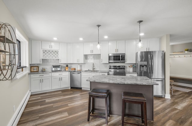 kitchen featuring stainless steel appliances, baseboard heating, a sink, white cabinets, and dark wood-style floors