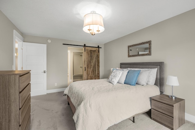 carpeted bedroom featuring baseboards and a barn door