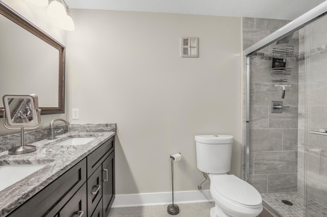 full bath with toilet, a shower stall, baseboards, and double vanity