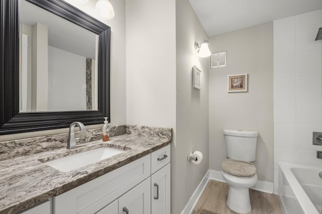 full bath with toilet, baseboards, wood finished floors, and vanity