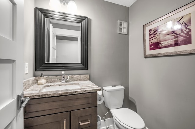 bathroom with vanity, toilet, and baseboards