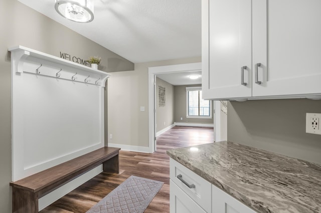 mudroom featuring dark wood-type flooring, baseboards, and a textured ceiling
