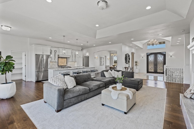 living area featuring recessed lighting, arched walkways, a chandelier, and a healthy amount of sunlight