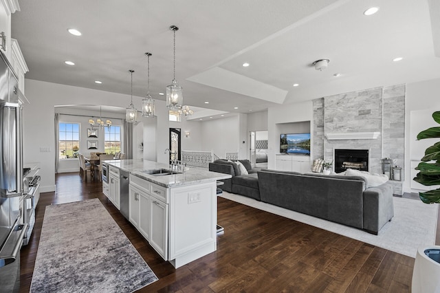 kitchen featuring a sink, an inviting chandelier, open floor plan, and dark wood-type flooring