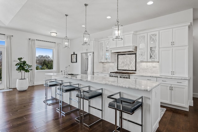 kitchen featuring stove, recessed lighting, white cabinetry, stainless steel built in fridge, and a sink