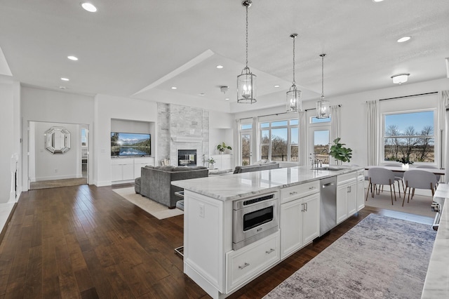 kitchen featuring a large island, recessed lighting, white cabinetry, light stone counters, and stainless steel appliances
