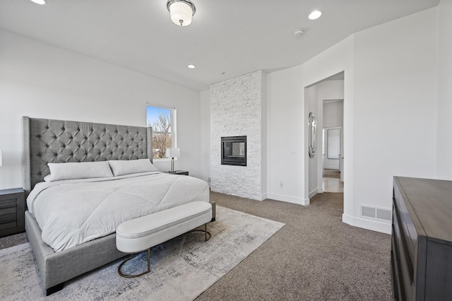 bedroom featuring visible vents, a fireplace, baseboards, recessed lighting, and dark carpet